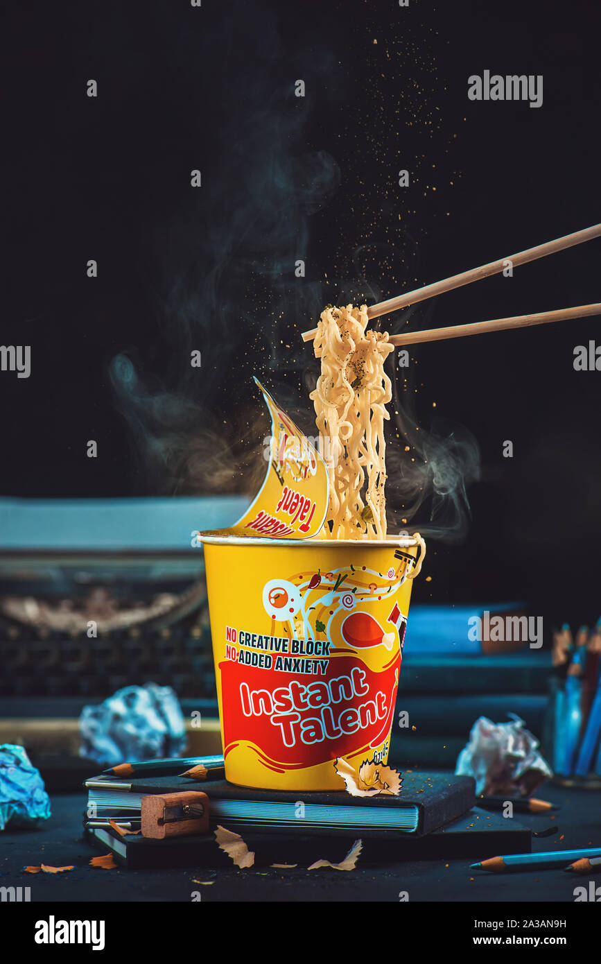 Instant ramen Pappbecher mit Stäbchen und Instant Talent label. Inspiration und schreiben Konzept, Schriftsteller Arbeitsplatz mit Bleistift und Notebooks Stockfoto