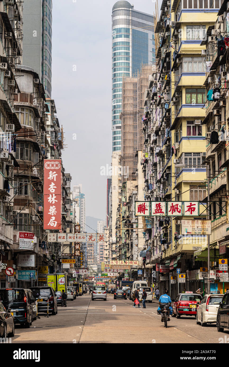 Hong Kong, China - 27. Januar 2019: Alte Wohnhäuser Kontrast mit einem modernen Wolkenkratzer in der Gasse, Mong Kok, Kowloon, Hong Kong Stockfoto
