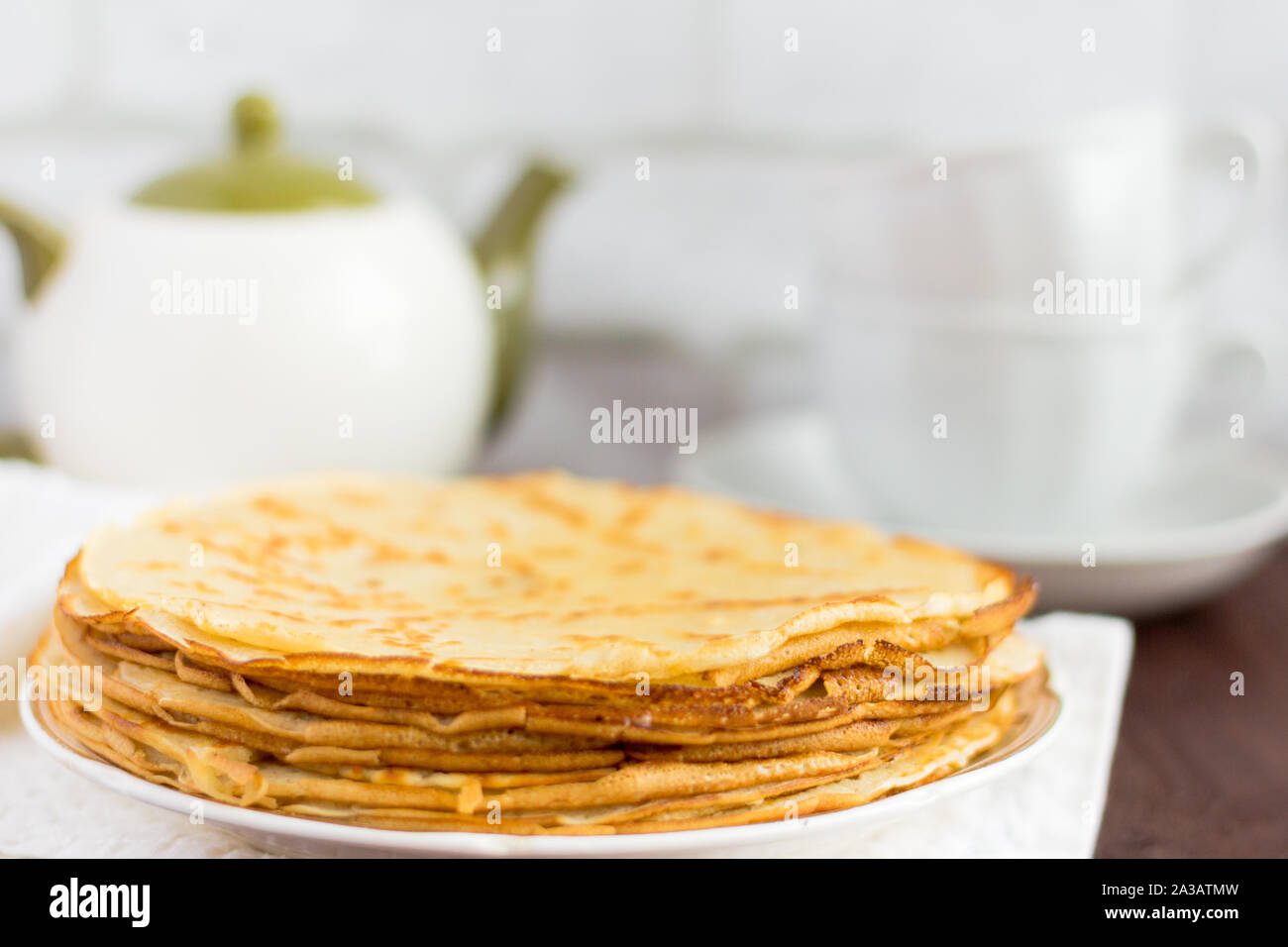 Hausgemachte frisch gebackenen Pfannkuchen auf dem Tisch und Kaffee Geschirr in den Hintergrund. Stockfoto