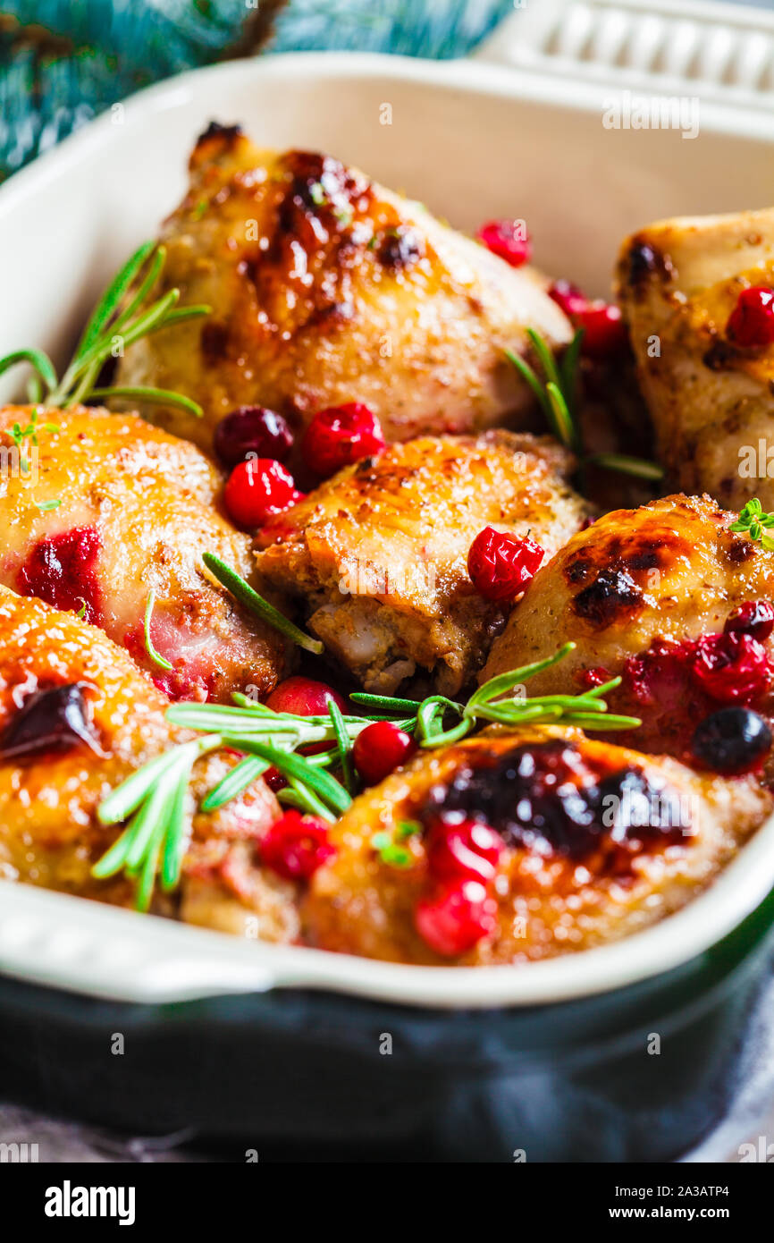 Weihnachten essen. Hähnchenfleisch gebacken mit Preiselbeeren und Rosmarin in die Auflaufform. Stockfoto