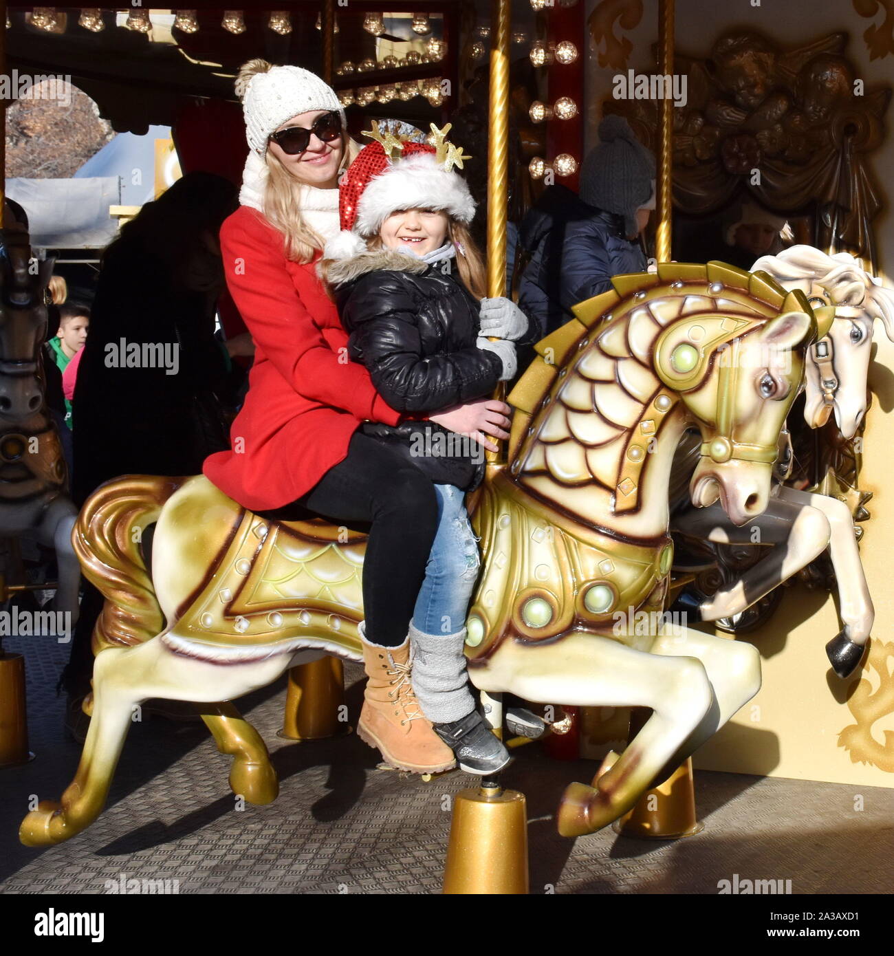 Nahaufnahme der Mutter und Kind reiten auf dem Karussell Pferd während der Weihnachtsfeiertage Stockfoto