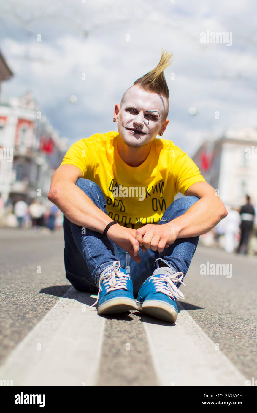 Belarus, die Stadt von Gimel, Juli 03, 2019. Jugend Festival. Der punk Kerl in helle Kleidung sitzen auf der Straße Stockfoto
