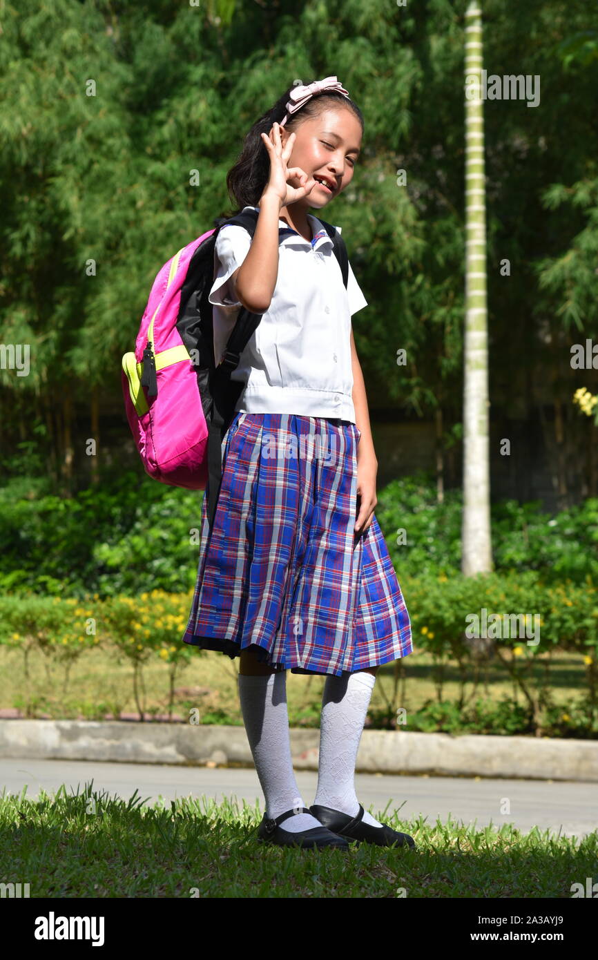 Okay Prep Filipina Person Uniform tragen mit Bücher Stockfoto