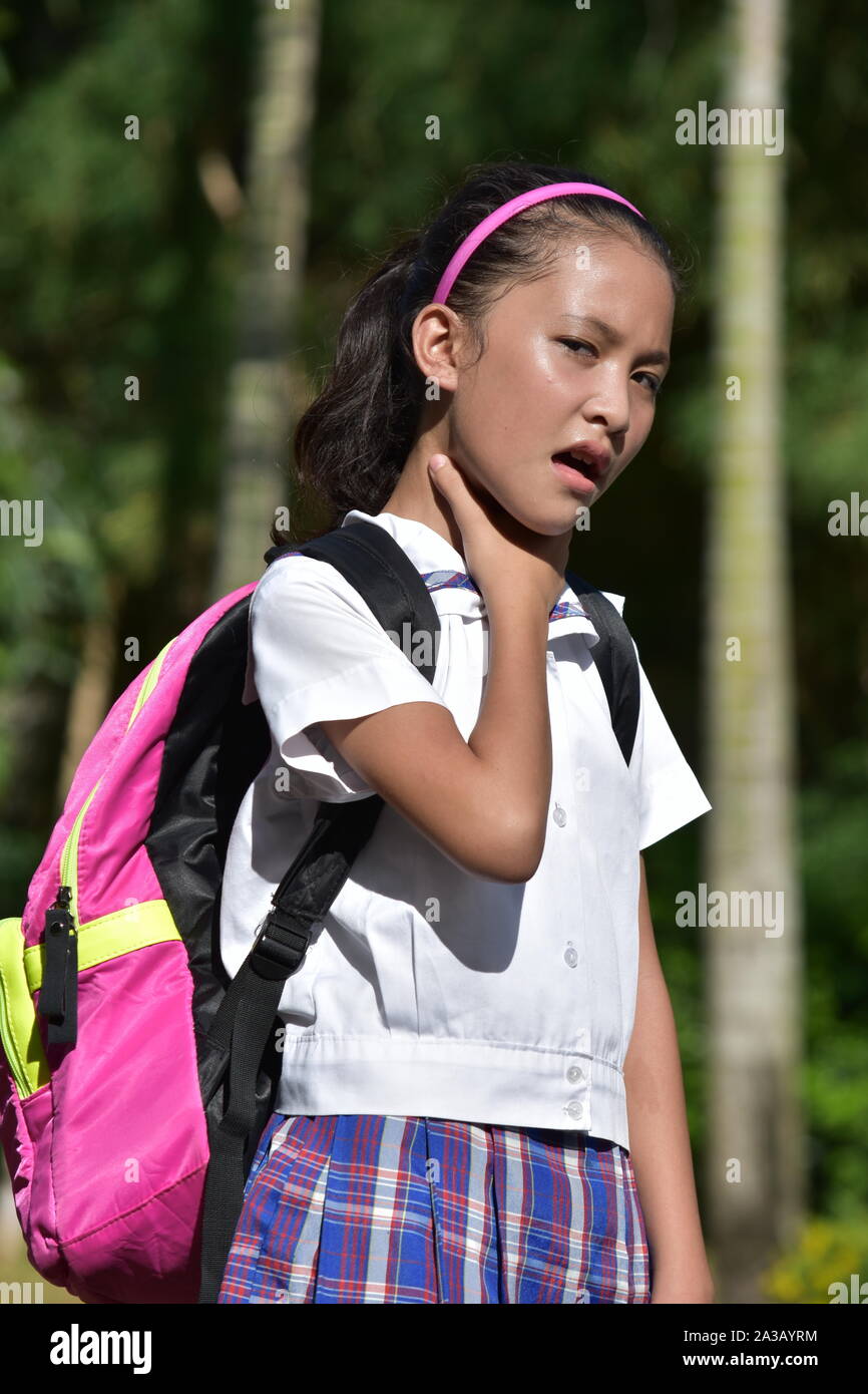 Junge Diverse Studentin mit Halsschmerzen tragen Schuluniform Stockfoto