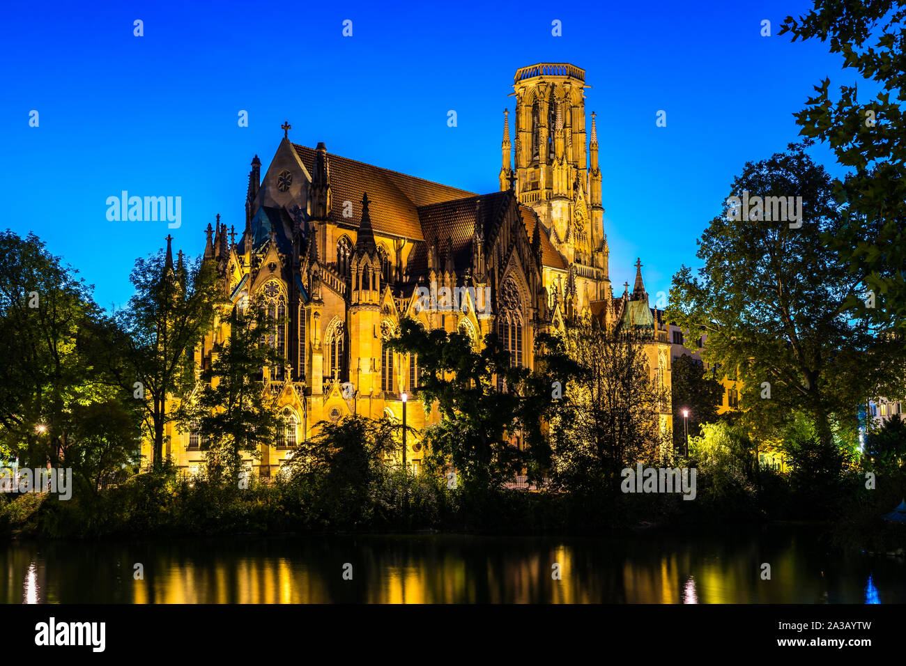 Deutschland, schöne Kirche des hl. Johannes, einer gotischen Kathedrale Gebäude in der Innenstadt von Stuttgart Feuersee, nachts beleuchtet, im Wasser widerspiegelt Stockfoto