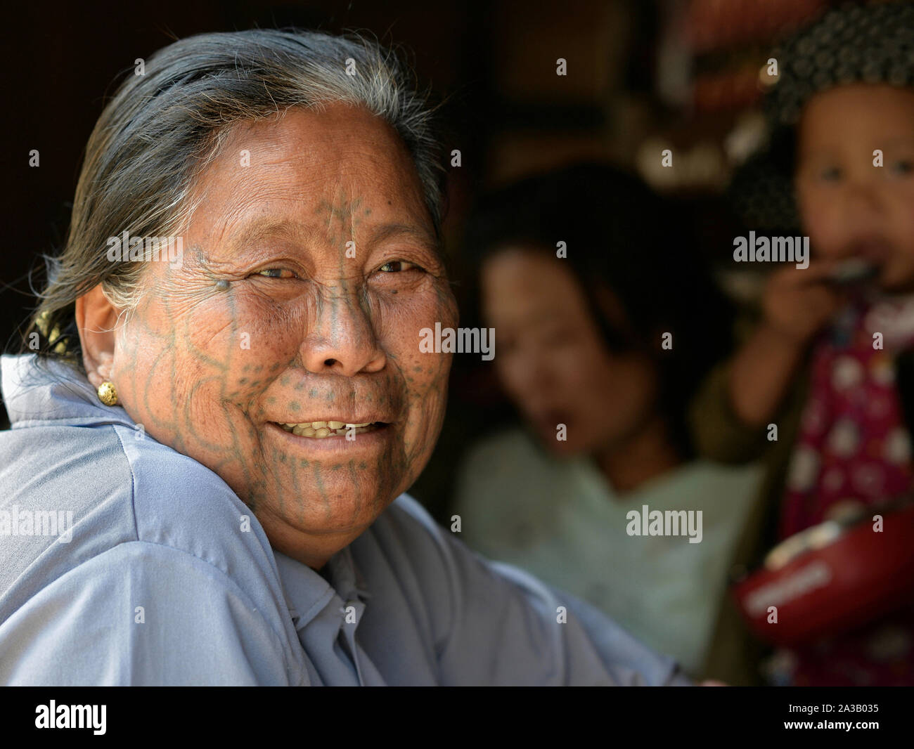 Ältere Menschen, großen Kinn Muun tribal Frau ('Spider Frau') mit klassischen Gesichtsbehandlung tattoo Lächeln für die Kamera. Stockfoto