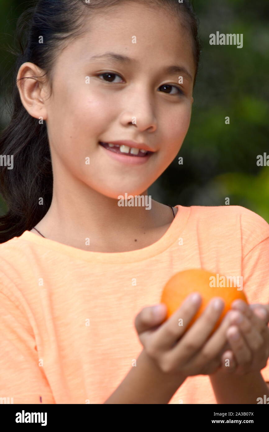 Lächelnd schöne asiatische weibliche Teenager mit einem orangefarbenen Stockfoto