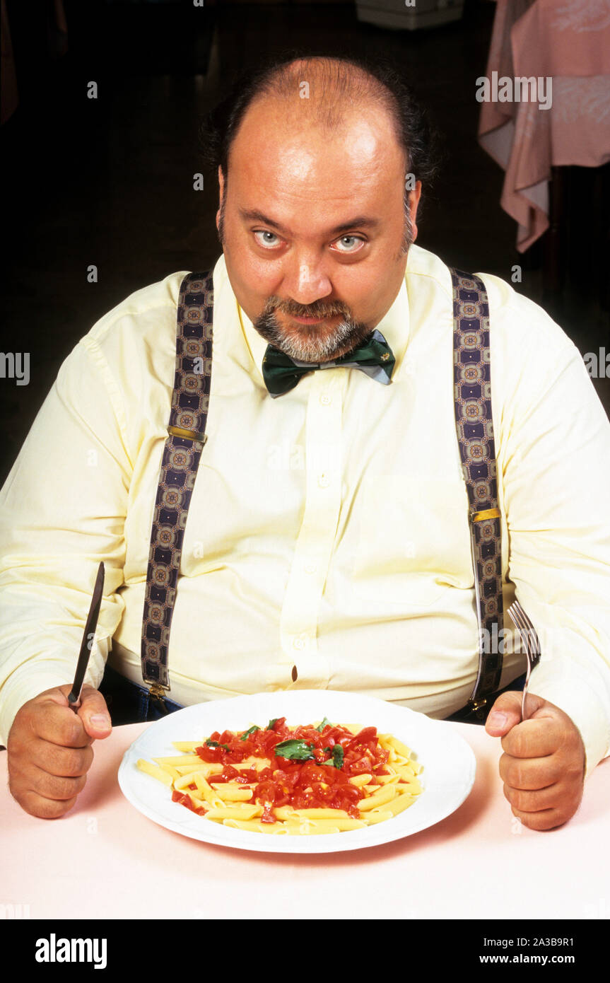 Fat man essen Pasta Stockfoto