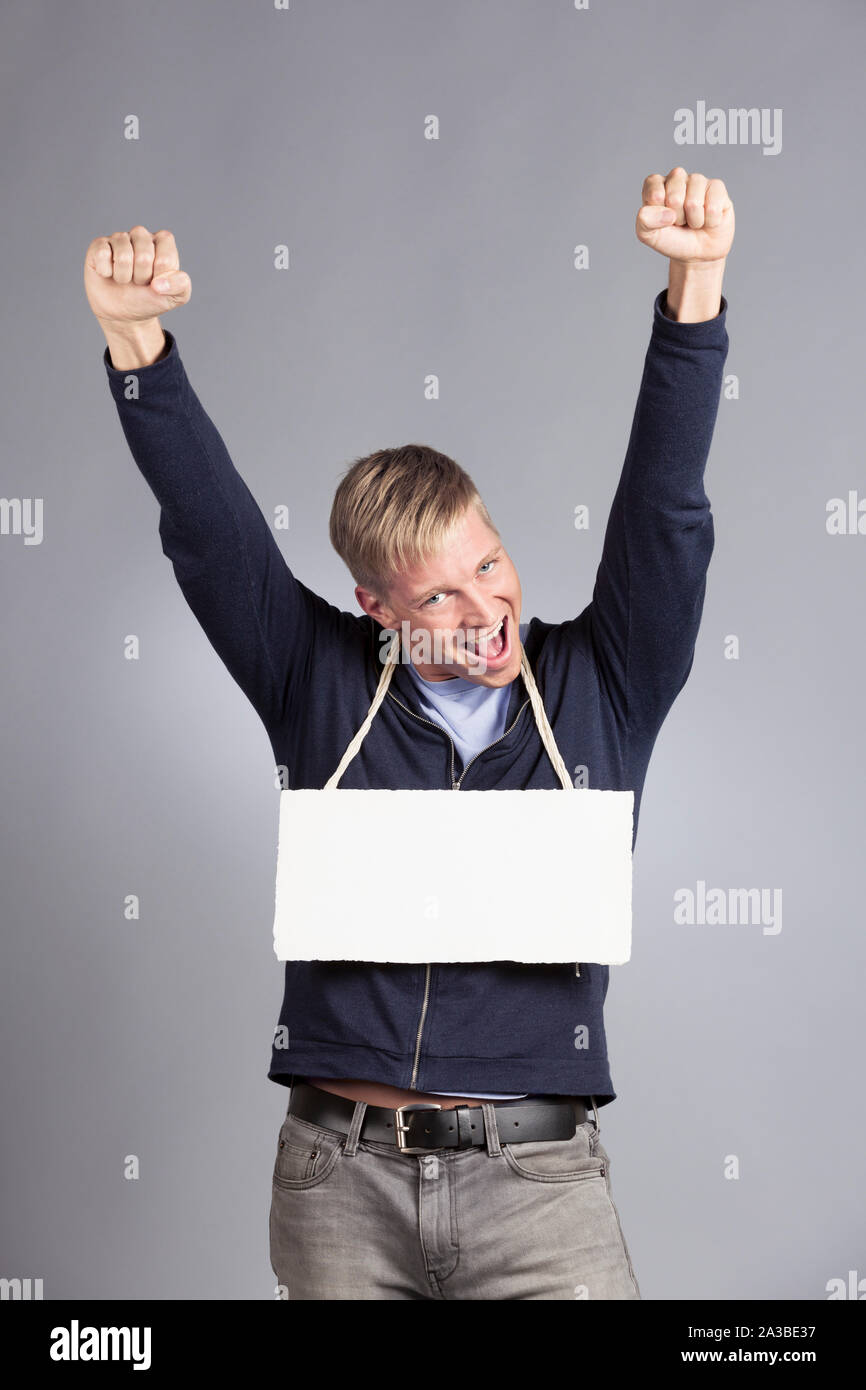 Erfolgreicher Mann zeigt leeres Namensschild aufgeregt. Stockfoto