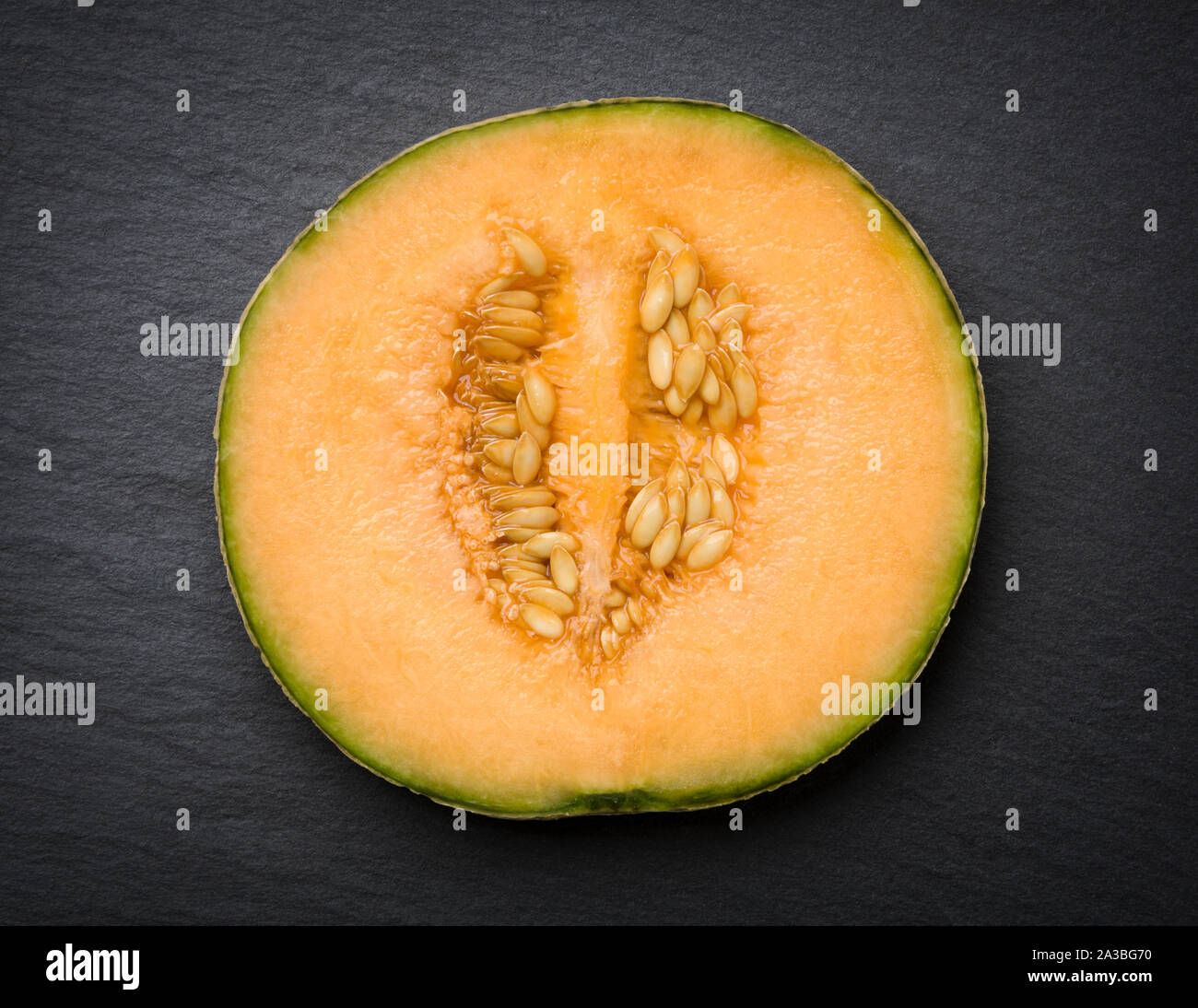 Moschus Melone in Scheiben geschnitten auf schiefer isoliert. Stockfoto