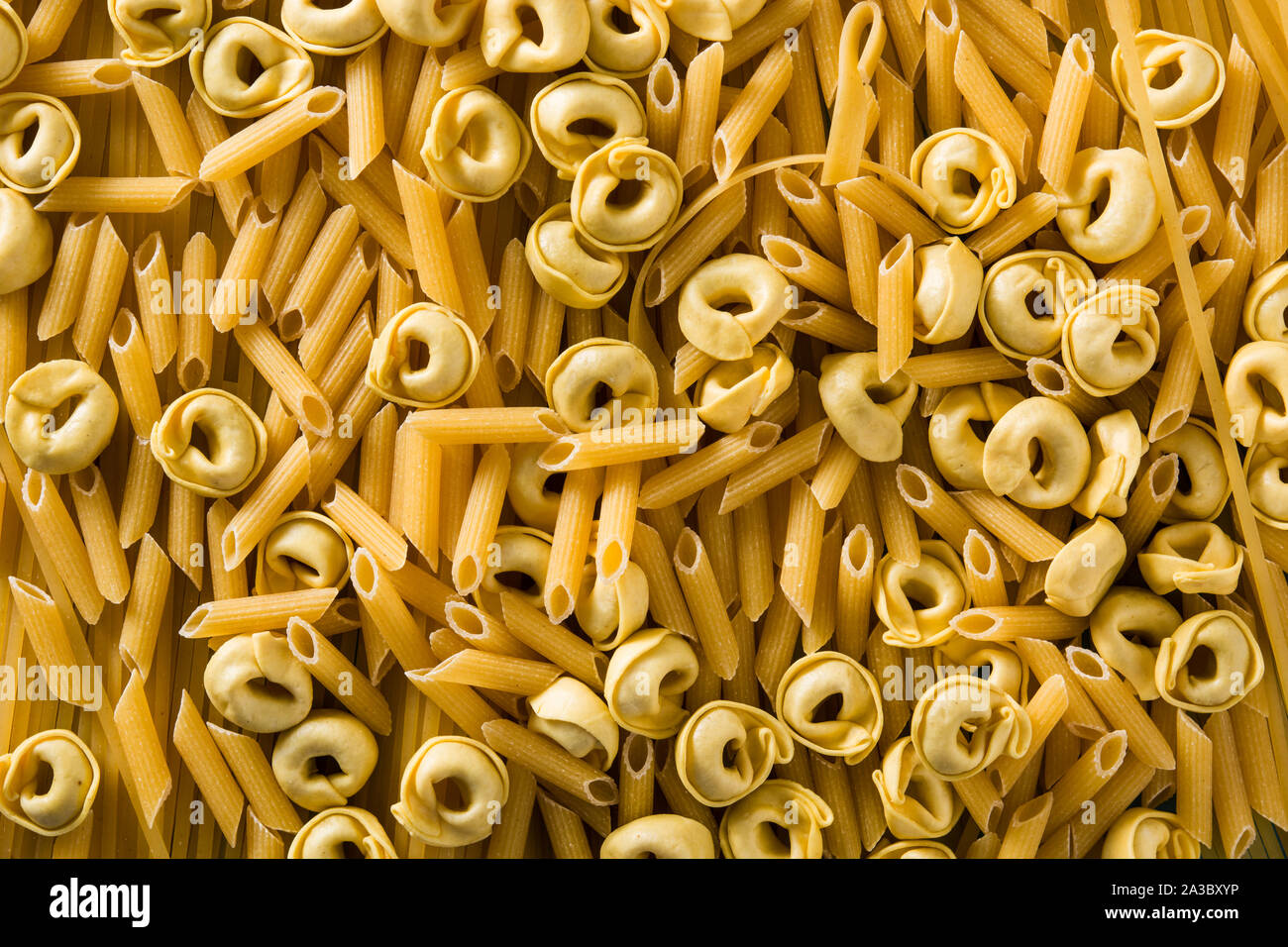 Verschiedene Arten von Pasta. Penne Pasta, Ravioli, Tortellini und capellini Hintergrund Stockfoto