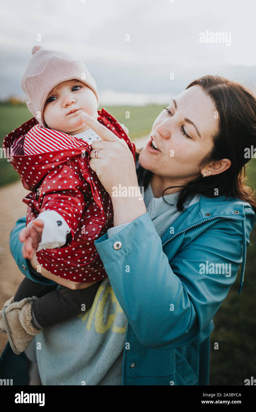 Mutter hält Ihr Baby Baby outdoor Herbst Szene, Familie lifestyle Konzept Stockfoto