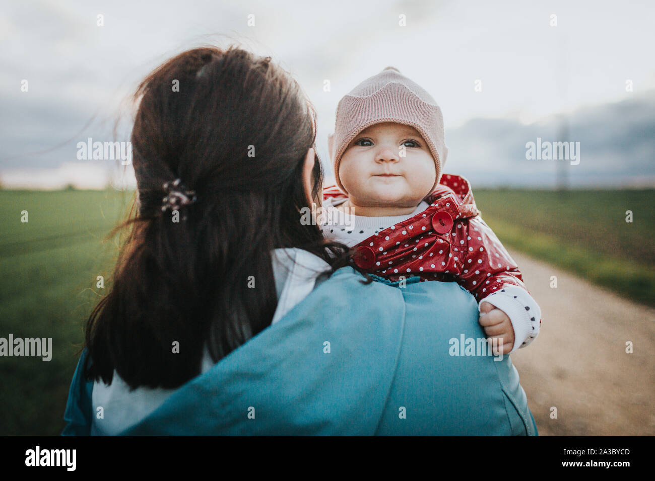 Kleinkind Baby schaut über Mütter Schulter - Herbst outdoor Familie lifestyle Konzept Stockfoto