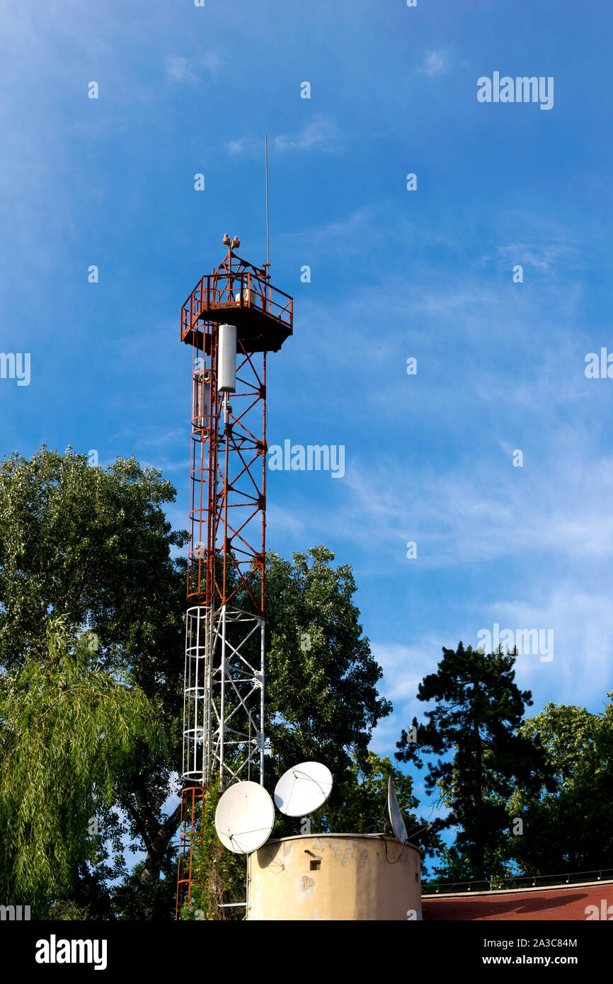 Metall Turm mit GSM-Antenne umgeben von grünen Bäumen - Copyspace Stockfoto