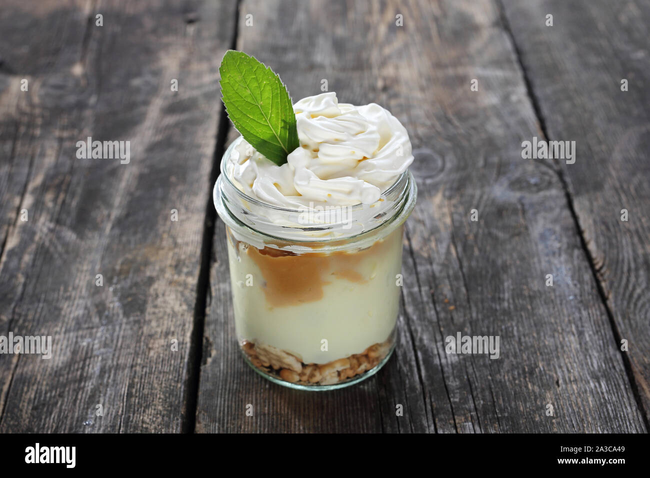 Dessert im Glas. Süßes, cremiges Dessert mit Schlagsahne Stockfoto