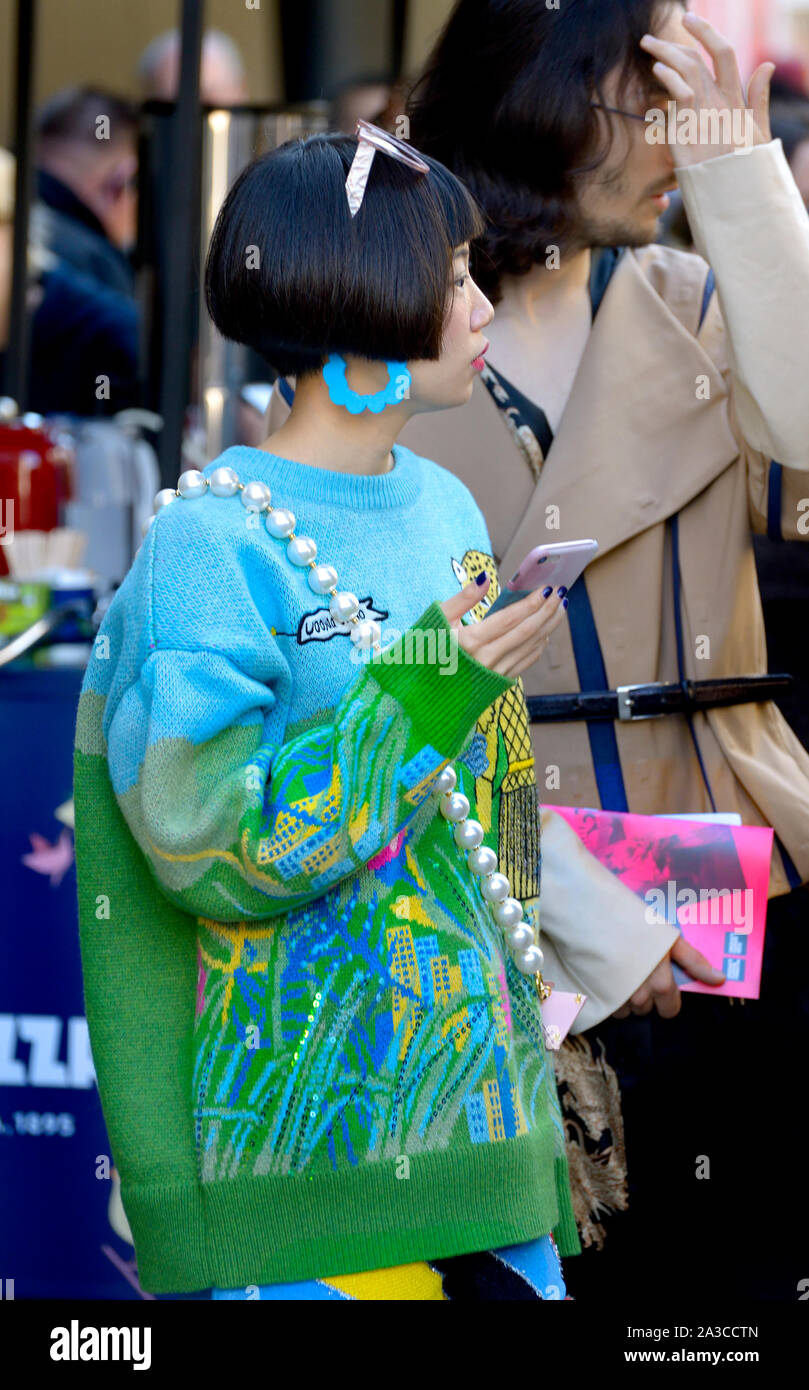 Asiatische Frau trägt eine bunte gestrickte Pullover an der London Fashion Week, 2019. Stockfoto