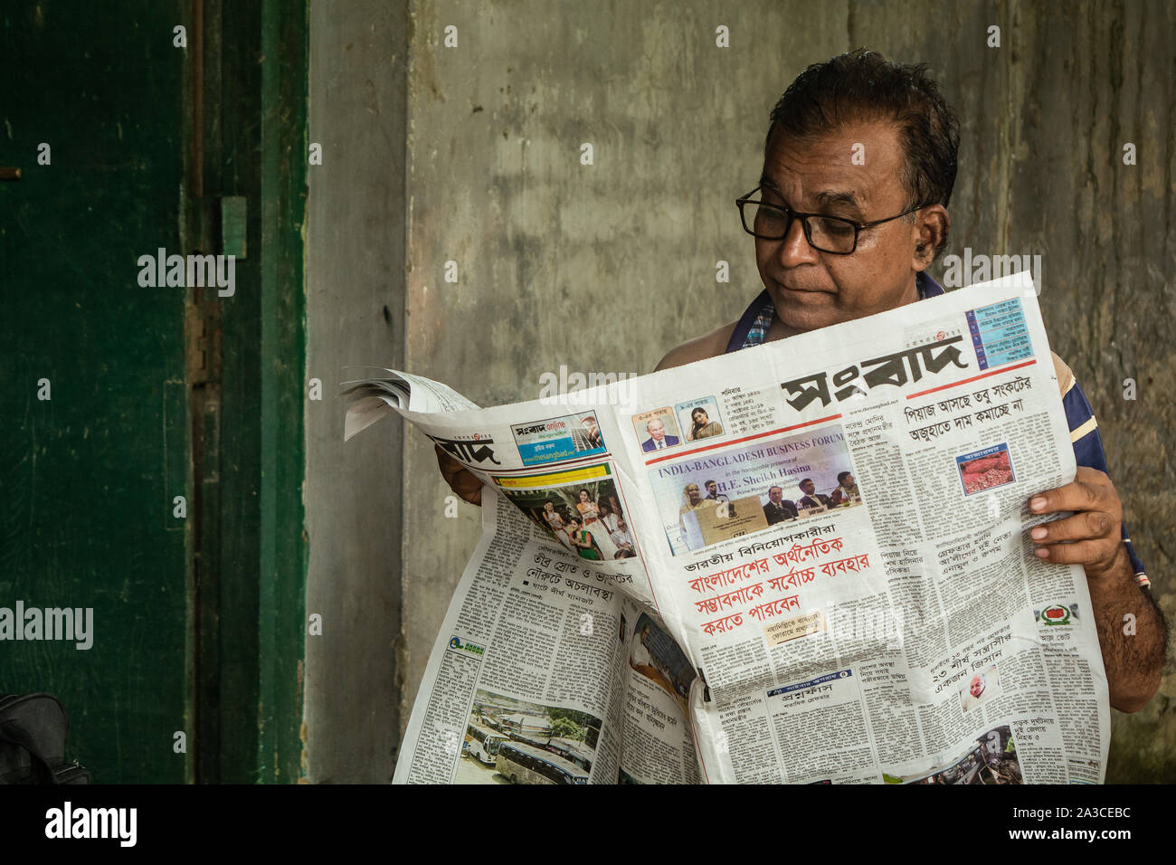 Älterer Mann liest Zeitung in seiner Speerzeit Stockfoto