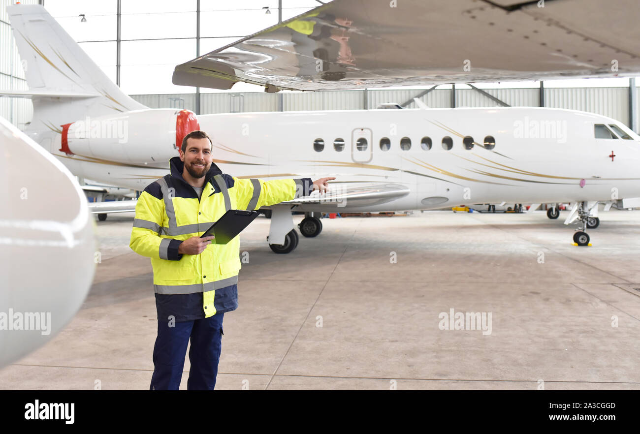 Flughafen Arbeitnehmer prüfen ein Flugzeug für die Sicherheit in einem Hangar Stockfoto