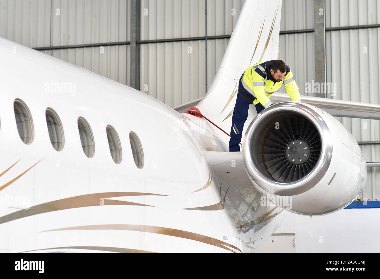 Fluggerätmechaniker inspiziert und überprüft die Technologie eines Jet in einem Hangar am Flughafen Stockfoto