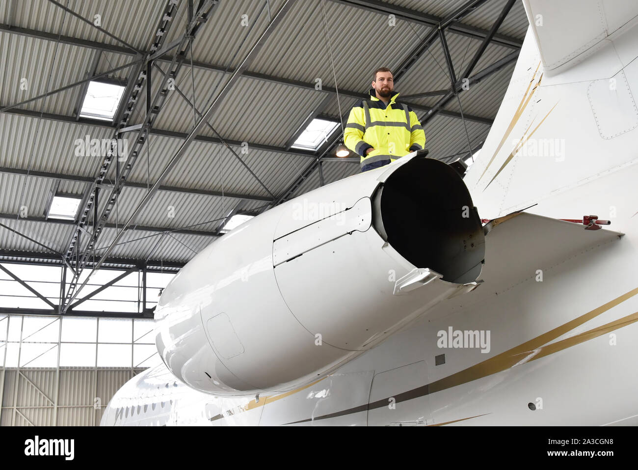 Flughafen Arbeitnehmer prüfen ein Flugzeug für die Sicherheit in einem Hangar Stockfoto