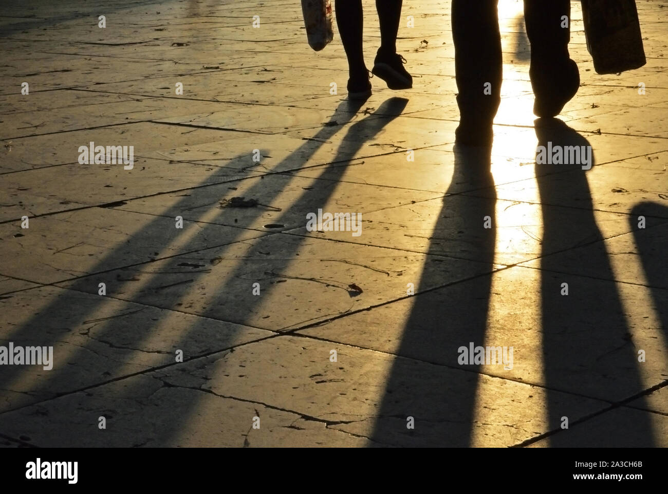 Bein Schatten auf Pflaster bei Sonnenuntergang Stockfoto