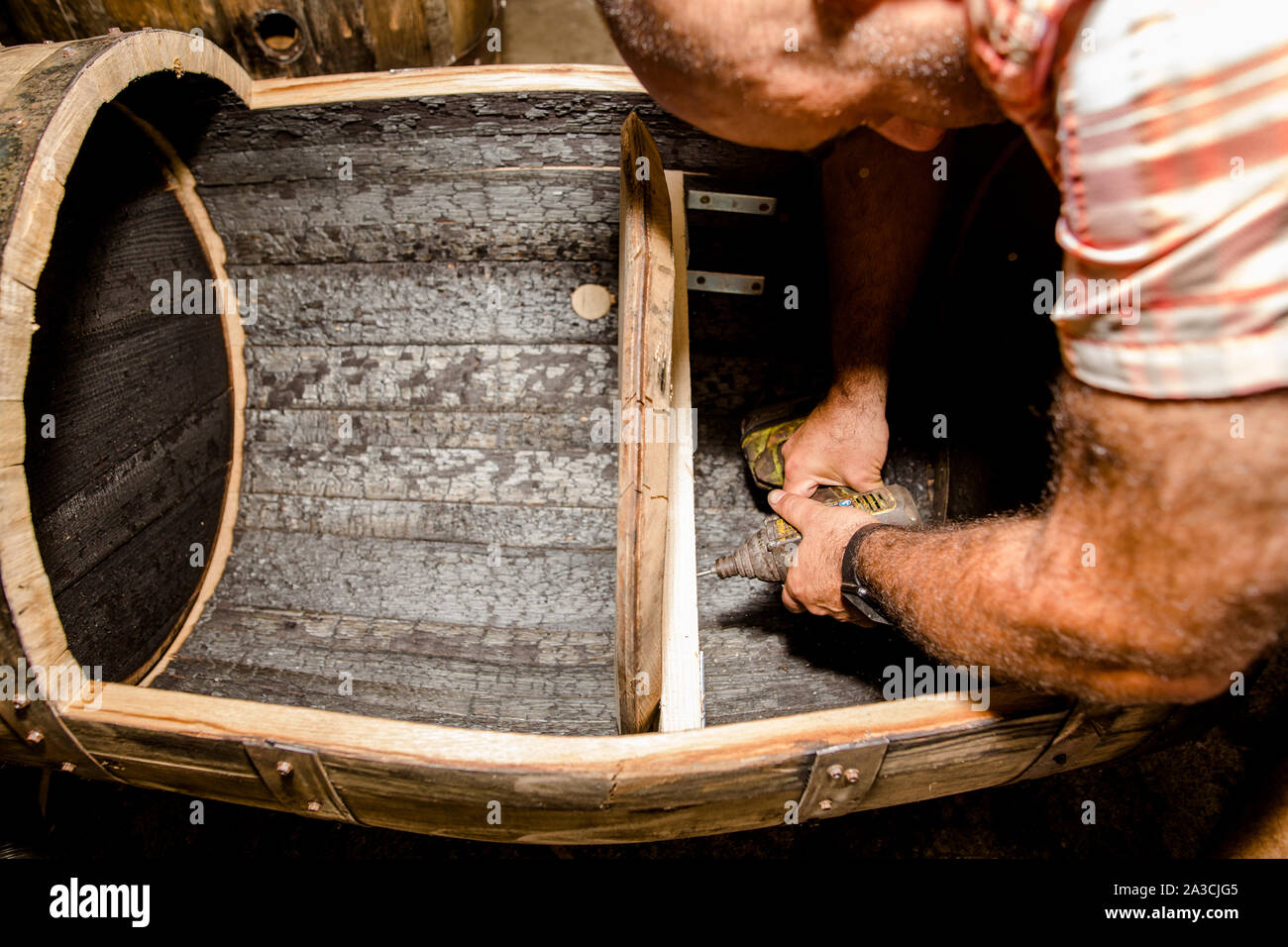 Ein Möbelhersteller baut ein Holzregal mit einer elektrischen Bohrmaschine Stockfoto