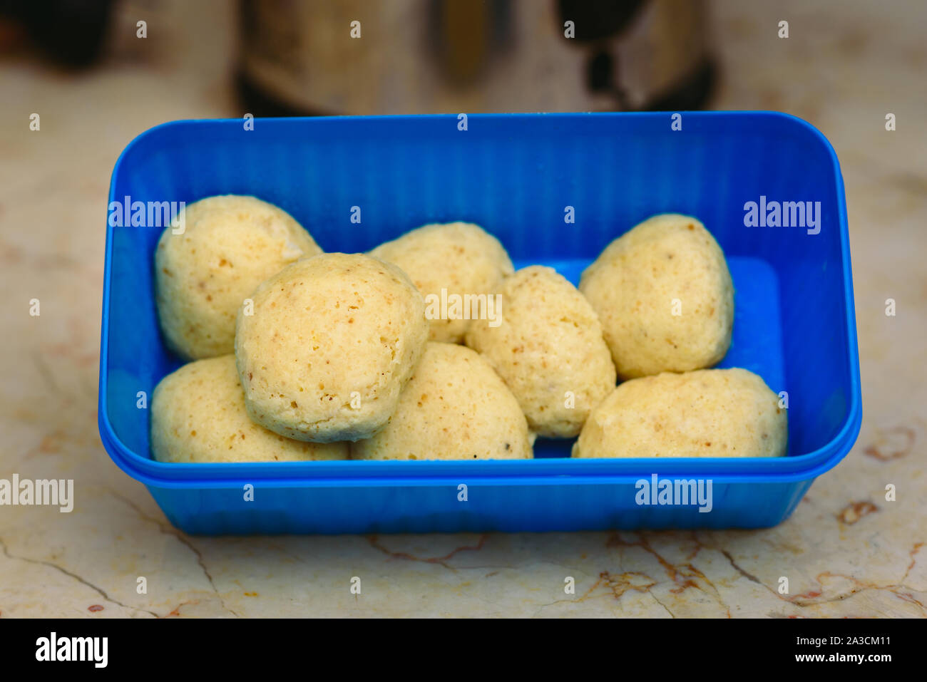 Traditionelle matzoh Ball kneidlach für Suppe. Blau Kunststoff Box mit authentischen matzo Ball für Huhn Geschmack heiße Suppe bouillon Tradition jüdischen Passah essen für jeden Tag. Stockfoto