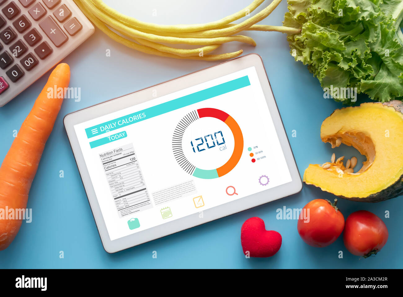 Kalorien zählen, Ernährung, der Kontrolle und Gewichtsverlust Konzept. Tablet mit Kalorienzähler Anwendung auf dem Bildschirm am Esstisch mit Gemüse- und Stockfoto