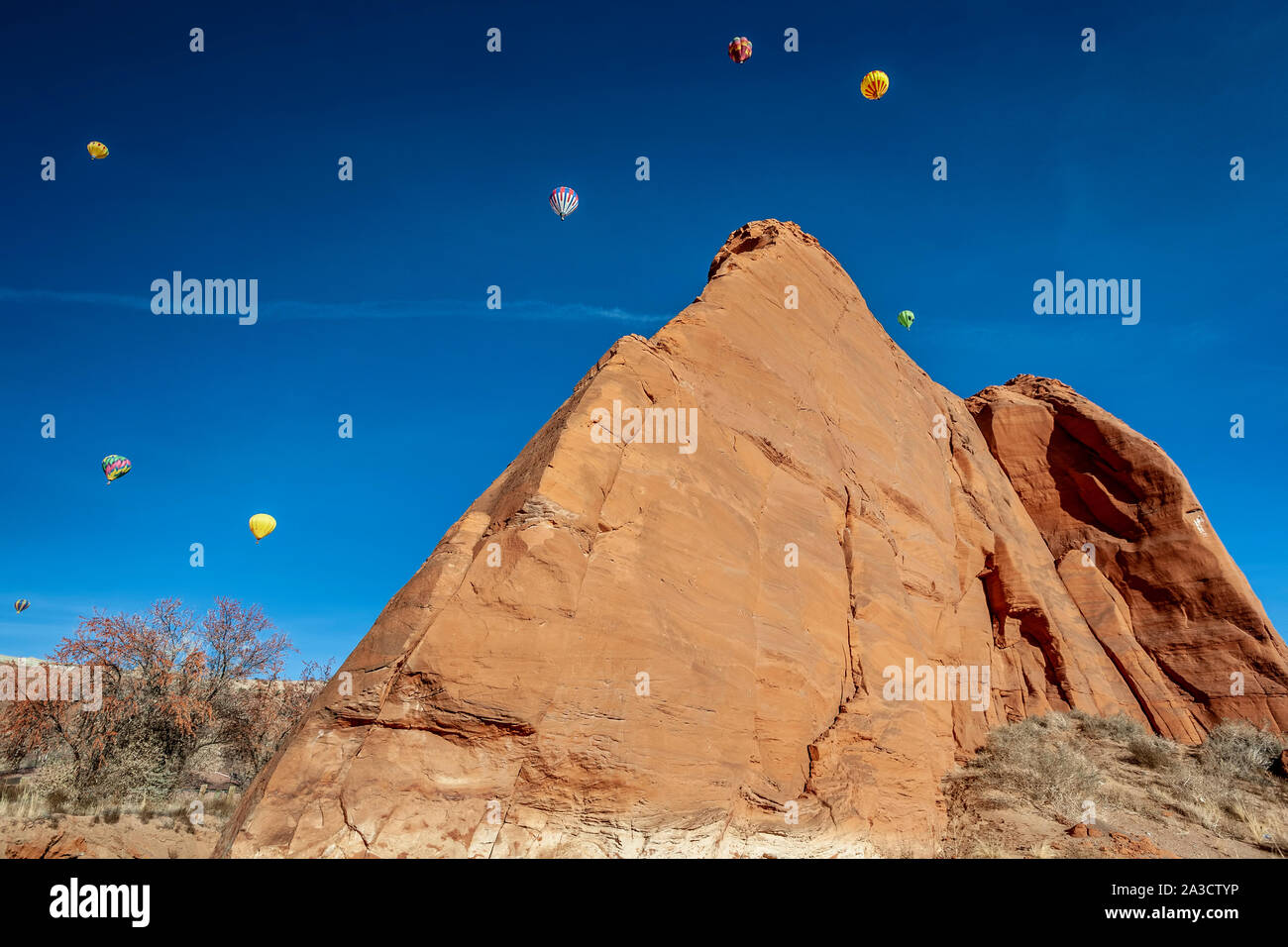 Heißluftballons und Sandsteinfelsen, der Himmelfahrt, Red Rock Balloon Rally, Gallup, New Mexico USA Stockfoto