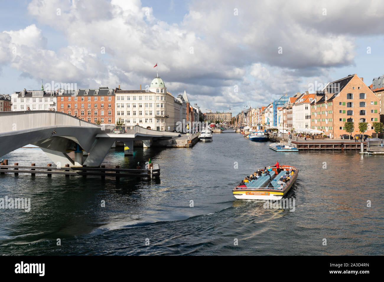 Kopenhagen, Dänemark: Inderhavnsbroen Fußgänger- und Zyklus Brücke. Ein touristenboot mit einem Führer, einem Kommentar in Nyhavn dreht. Stockfoto