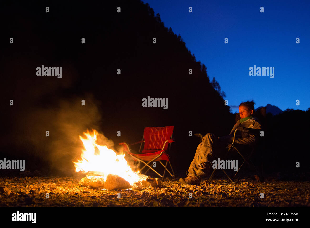 Das sitzen an einem leuchtenden Lagerfeuer in der Wildnis bei Nacht, Freiheit Camping in schöner Natur, Valbona Tal, Albanien Stockfoto