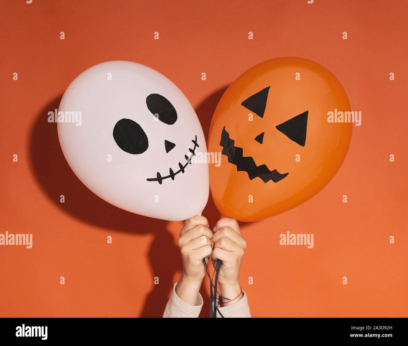 Geist und Kürbis Halloween Luftballons in Frau Hände Stockfoto