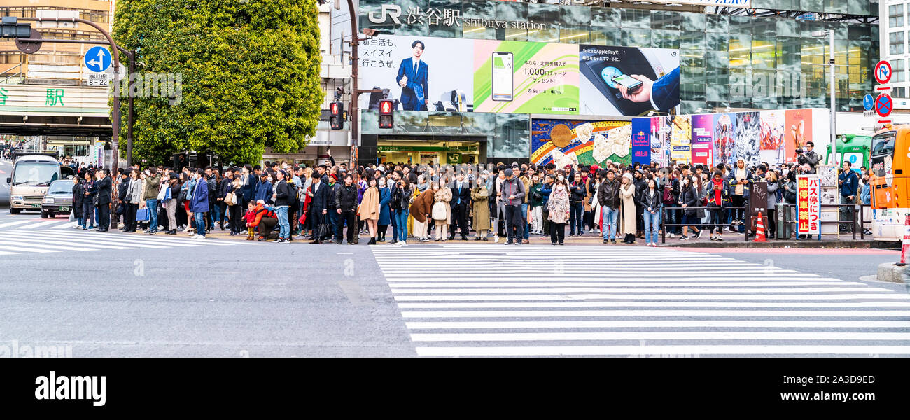 Tokio. Shibuya. Die berühmten Scramble Crossing. Blick über die Straße von Menschen außerhalb der JR Bahnhof Shibuya warten auf Licht, um die Straße zu überqueren. Stockfoto