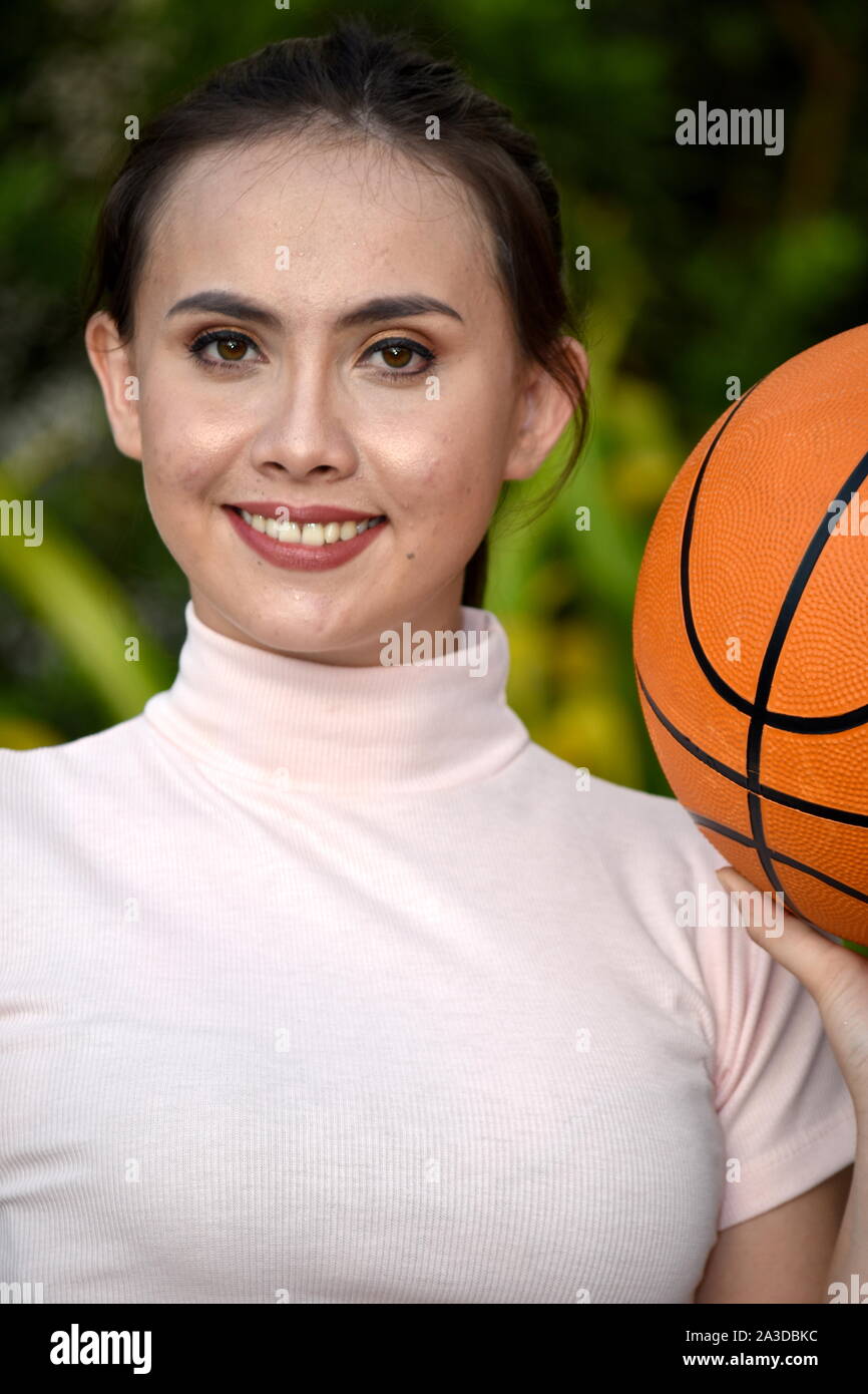 Lächelnd sportliche Minderheit weiblichen Athleten mit Basketball Stockfoto