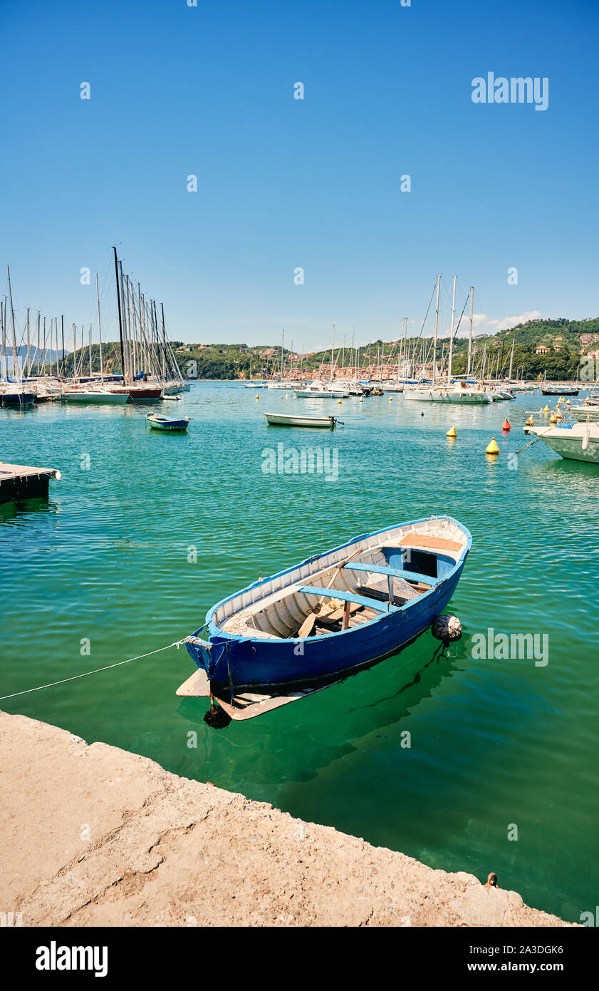Farbenfrohe blaue Schiff gebunden schwimmend auf klare blaue Wasser, das gegen die Yachten in der ruhigen Bucht Stockfoto