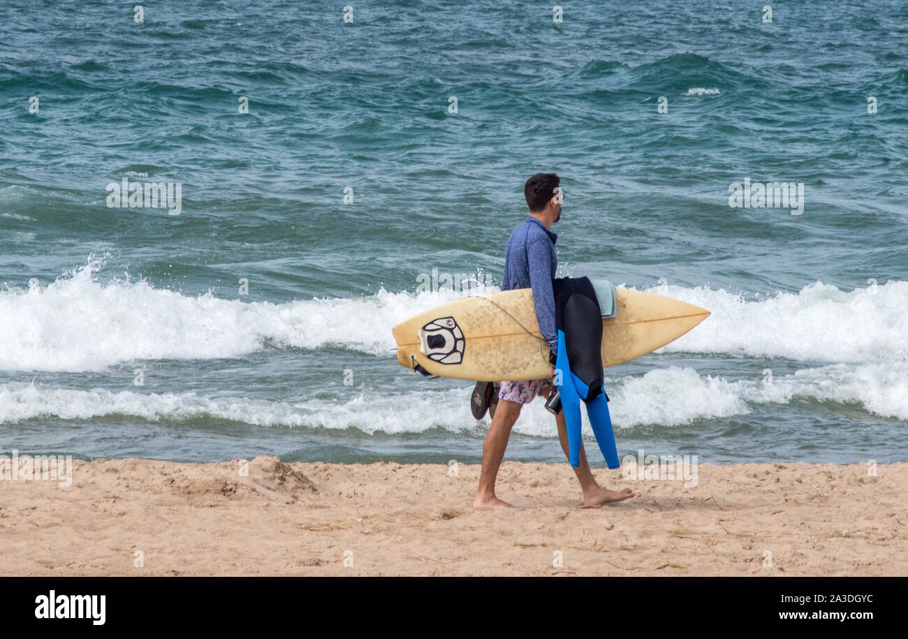 St Joe Michigan, USA, 14. September 2019; ein Surfer trägt seinen Neoprenanzug und Surfbrett, auf der Suche nach guten Spot Surfen auf dem aktiven Wellen zu tun Stockfoto