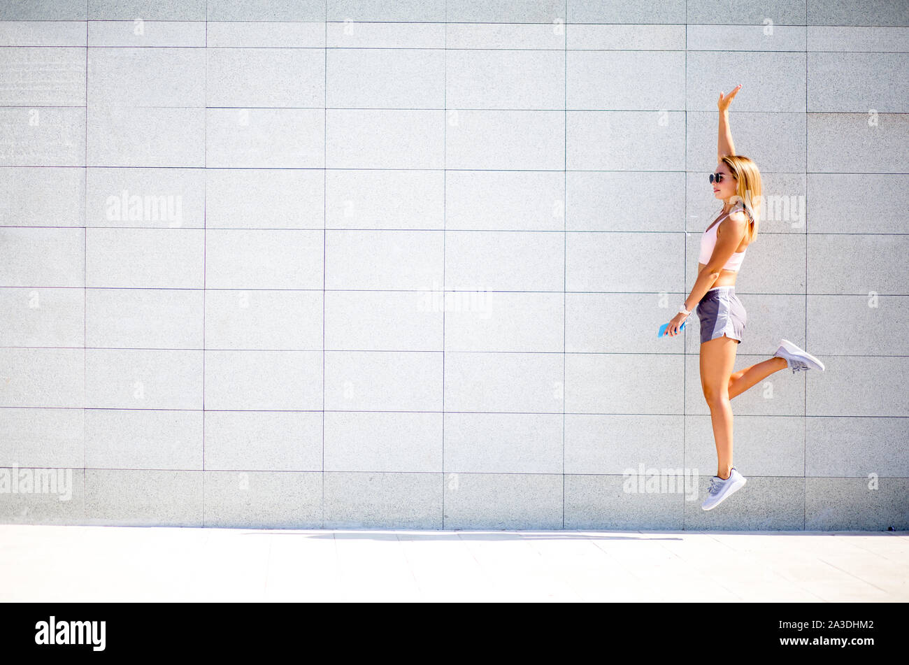 Schönen weiblichen Läufer oben springen Arbeit Übungen im Freien. Fitness Frau eine Pause nach dem Workout. Stockfoto