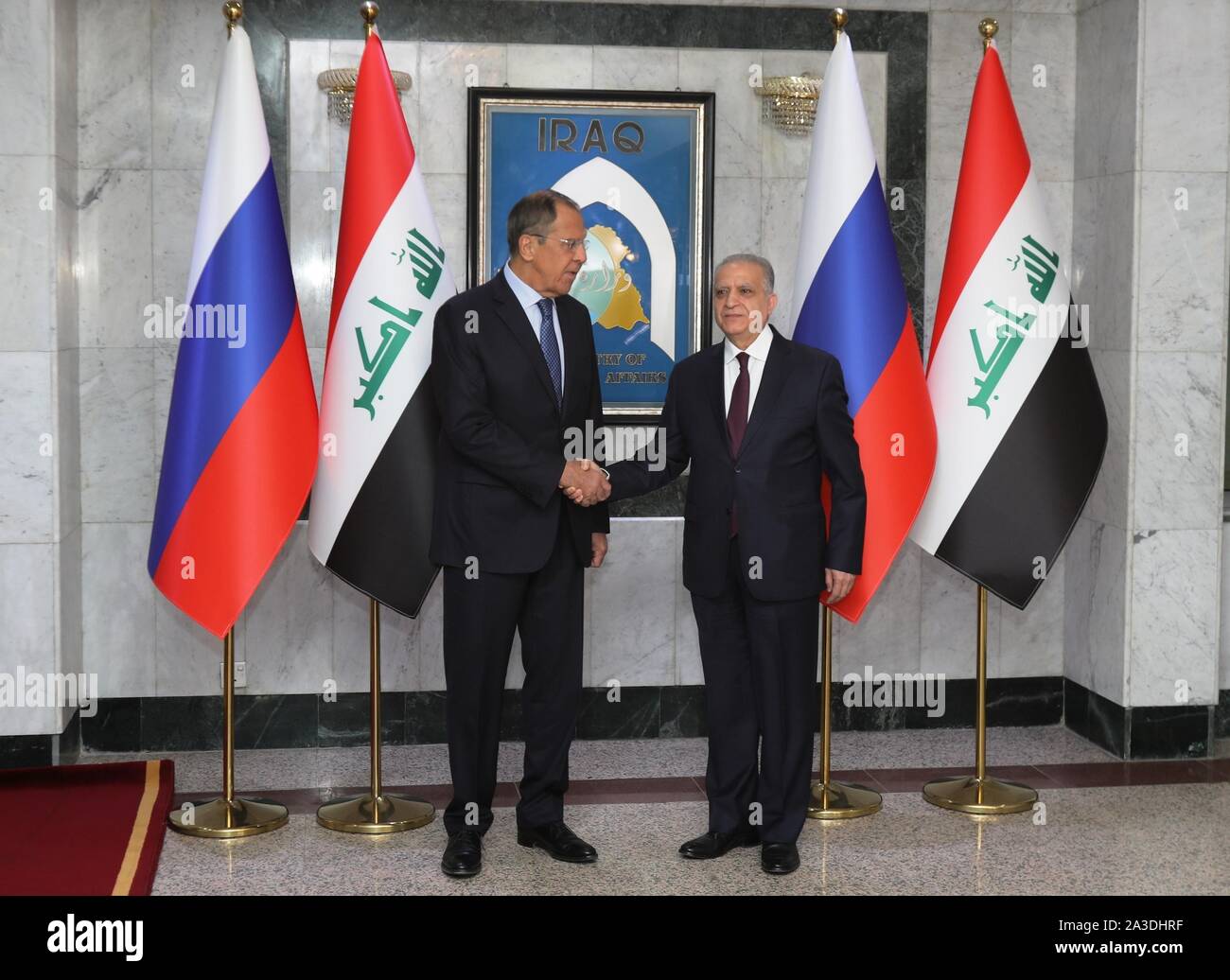 Bagdad, Irak. 7 Okt, 2019. Irakischen Außenminister Mohammed al-Hakim (R) schüttelt Hände mit dem russischen Außenminister Sergej Lawrow in Bagdad, Irak, am 7. Oktober, 2019. Mohammed al-Hakim und seinem russischen Amtskollegen Sergej Lawrow am Montag hier genannt für die zunehmenden Bemühungen der Spannungen in der Golfregion zu verringern und die Rückkehr von Syrien die Arabische Liga (AL). Quelle: Khalil Dawood/Xinhua/Alamy leben Nachrichten Stockfoto