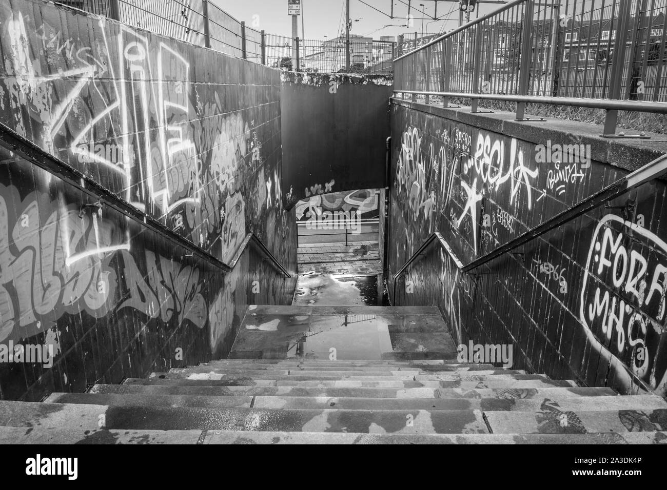 Ein schwarz-weiß Bild von er öffentlichen Fußgänger Tunnel unter den Bahngleisen in der Innenstadt von Maastricht, ist der Kanal voll ist von Graffiti, Tags und andere Weise Stockfoto
