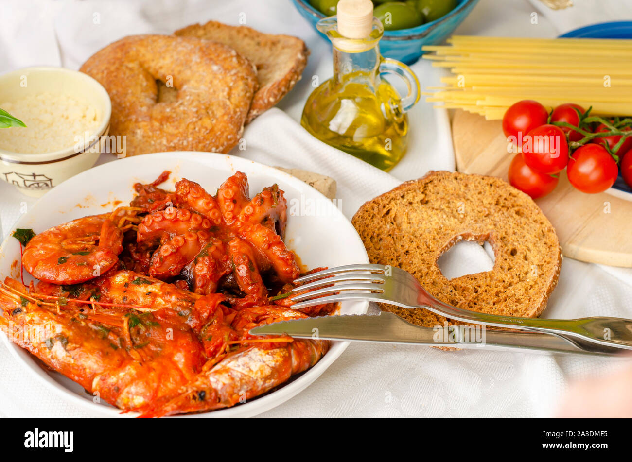 Lecker Abendessen für die Liebhaber von Meeresfrüchten. Garnelen und Tintenfische in Tomatensauce. Italienisches Essen Konzept. Stockfoto