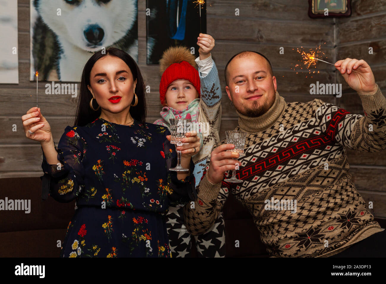 Europäische Familie feiert mit Weingläsern und Wunderkerzen Stockfoto