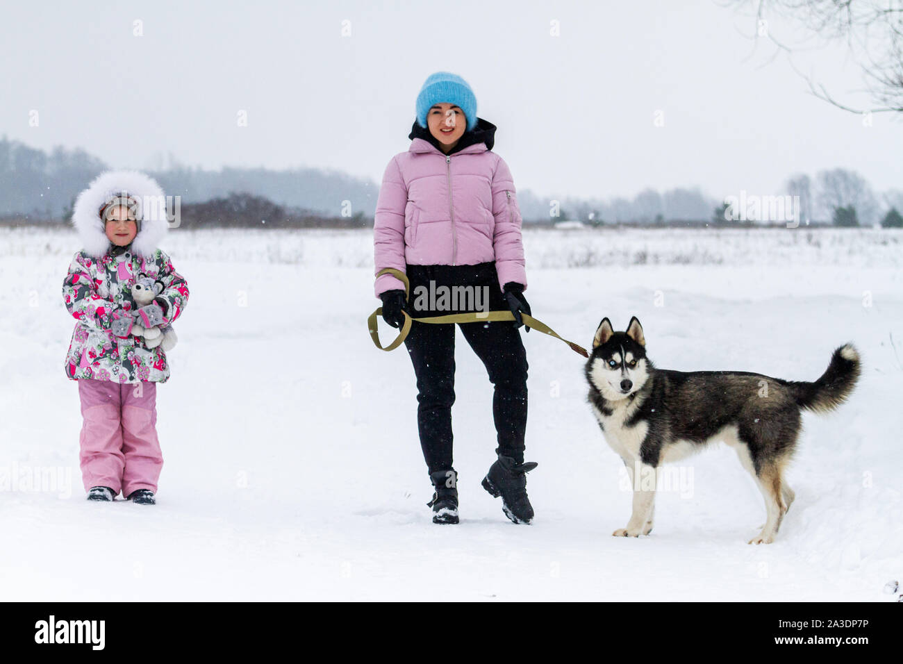 Mutter und Tochter gehen der Hund an einem Wintertag Stockfoto