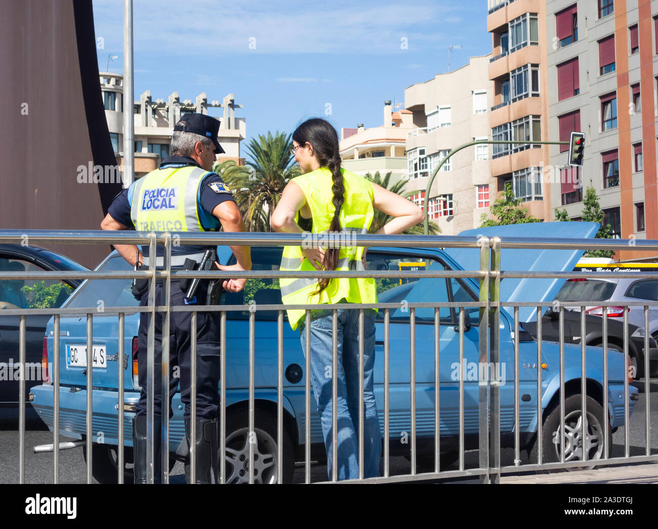 Weibliche Treiber für Pannenhilfe Fahrzeug sprechen auf der belebten Straße auf die Polizei in Spanien warten Stockfoto