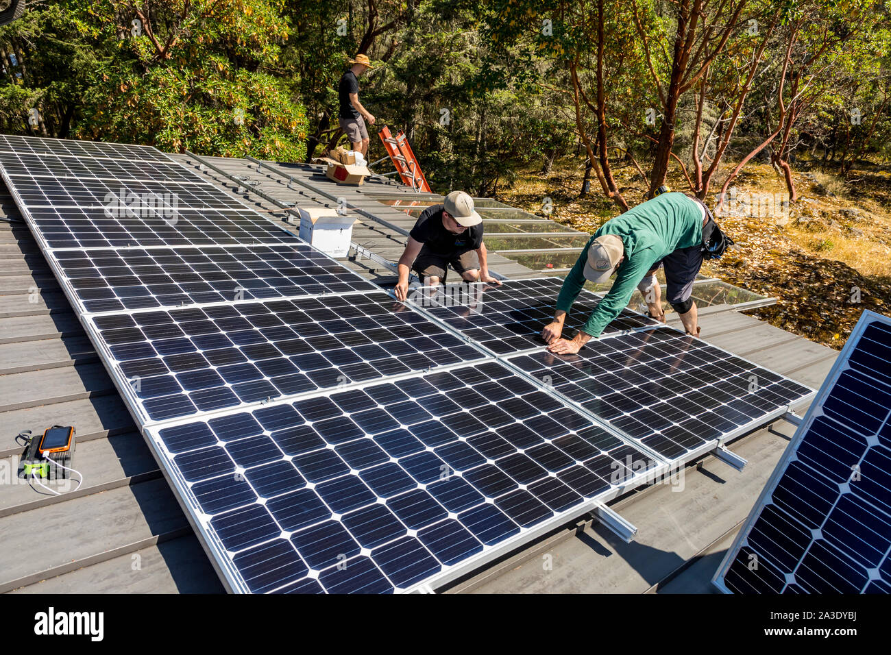 Arbeitnehmer installieren solar Photovoltaikmodule auf einem Eigenheimbesitzer Dach in British Columbia, Kanada. Stockfoto