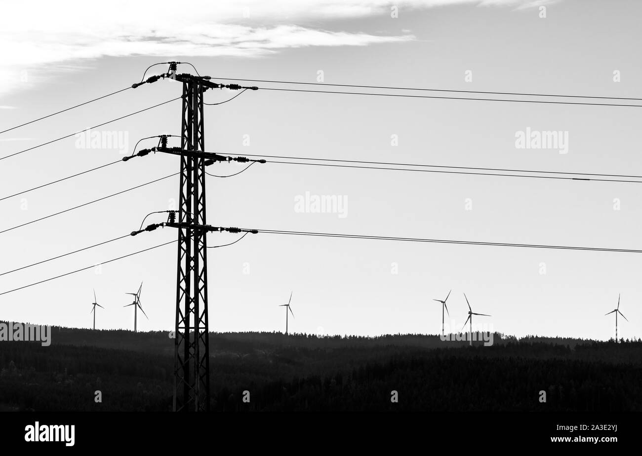 Stromversorgungsnetz Turm und Gruppe von Windenergieanlagen. Schwarz-weiße Silhouette. Strom Pylon und alternative erneuerbare Energiequellen in der Landschaft. Stockfoto