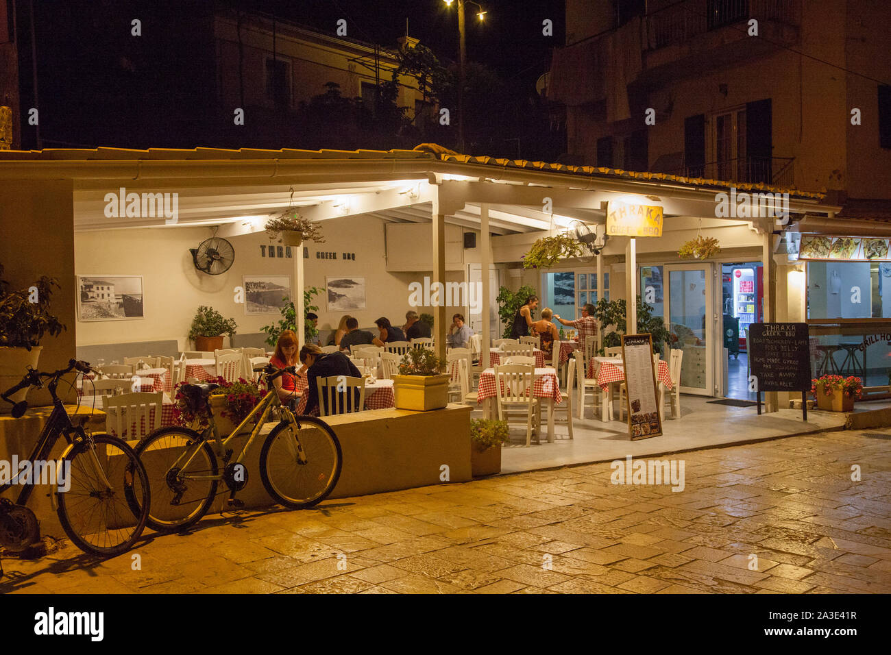 Nächtliche Aussicht auf ein griechisches Restaurant Taverna mit Menschen in Essen an der griechischen Resort von Kassiopi Korfu Griechenland Stockfoto