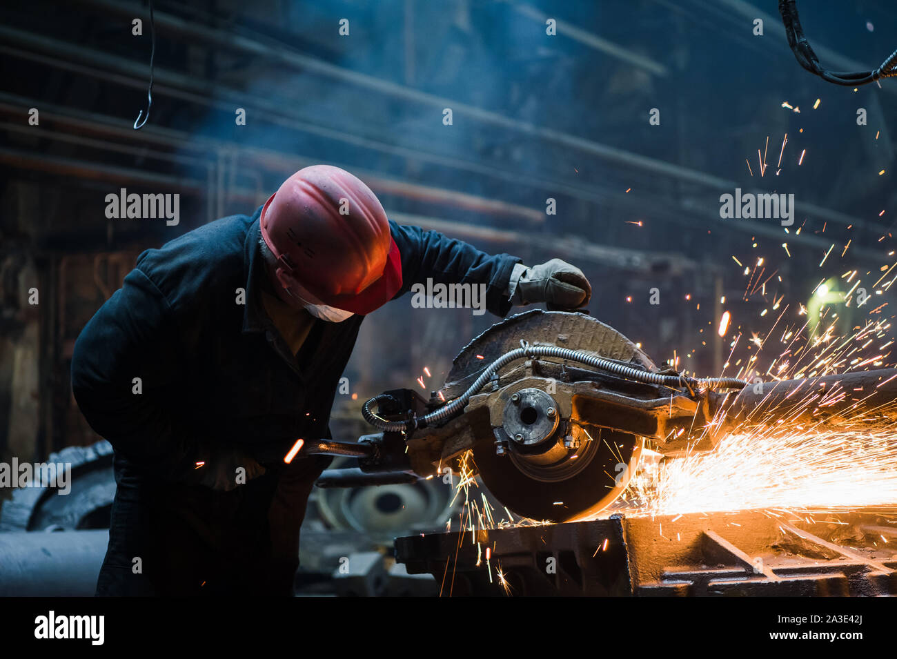 Mitarbeiter schleifen Stahl mit Funken - Fokus auf Schleifer. Steel Factory. Stockfoto