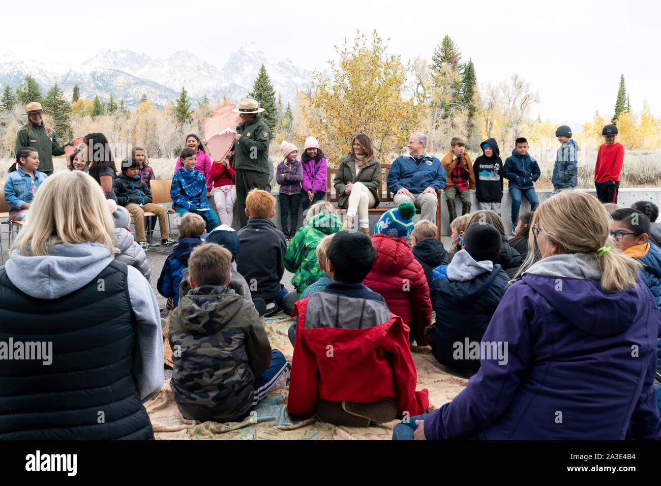 Us-First Lady Melania Trump mit Innen Sekretär David Bernhardt (rechts) beobachten, wie Kinder in der Pfeilspitze Zeremonie während eines Besuchs bei der Craig Thomas Discovery Center im Grand Teton National Park Oktober 4, 2019 in Elche, Wyoming teilnehmen. Stockfoto