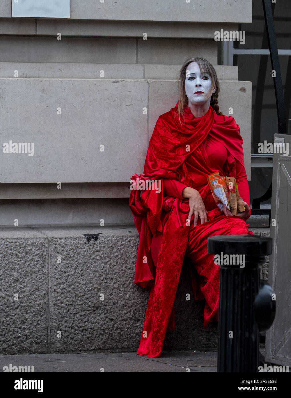 Die Westminster Bridge, London UK. 7. Oktober 2019. Bridge, London UK. Aussterben rebellion Klimawandel Aktivisten protestieren auf die Westminster Bridge. Ein erschöpfter 'Red Rebel" nimmt einen Bruch am ersten Tag der Proteste in London. Celia McMahon/Alamy Leben Nachrichten. Credit: Celia McMahon/Alamy leben Nachrichten Stockfoto