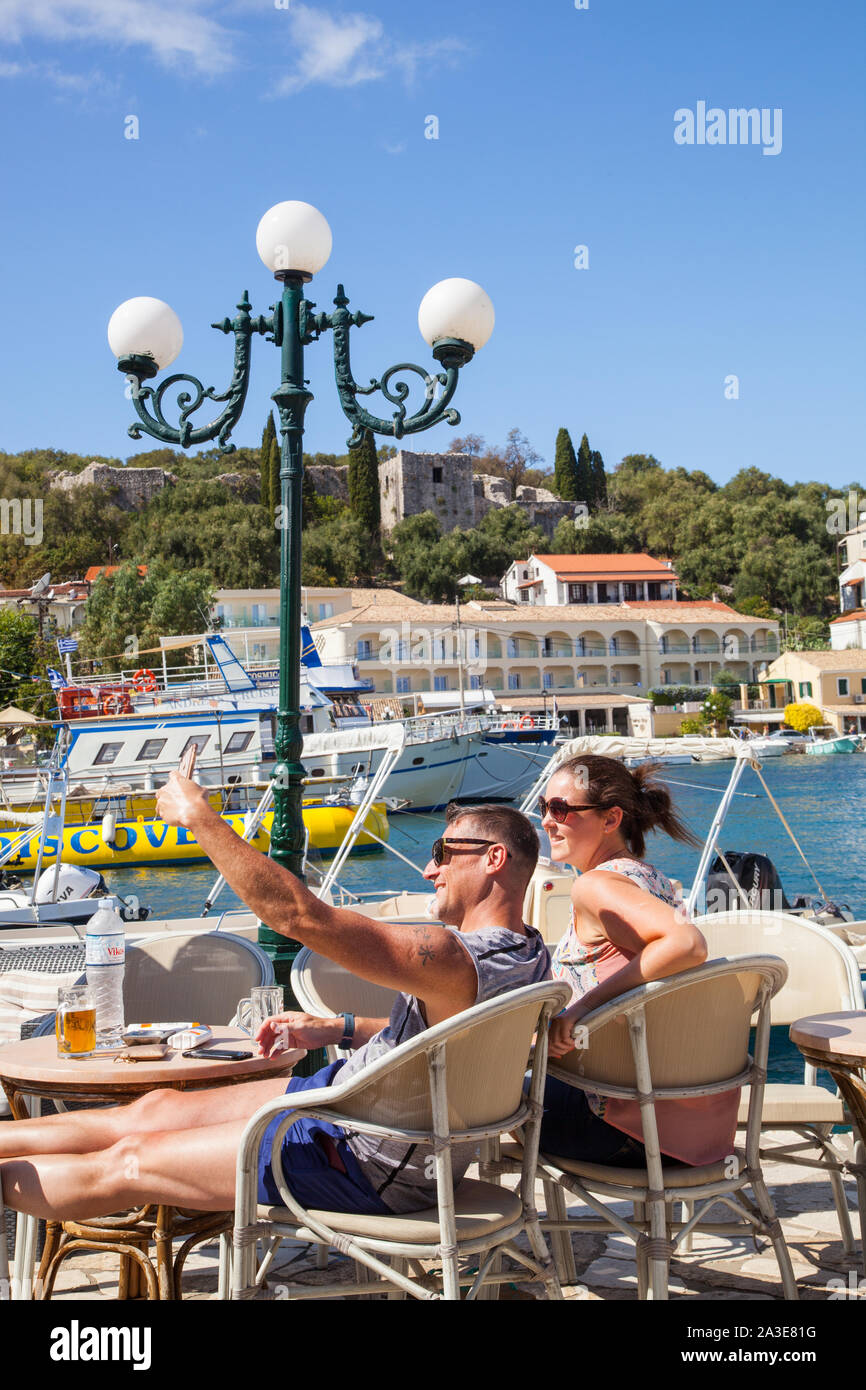 Mann und Frau die selfie Foto trinken an der Cafés und Bars rund um den Hafen an der griechischen Ferienort Kassiopi Korfu Griechenland Stockfoto